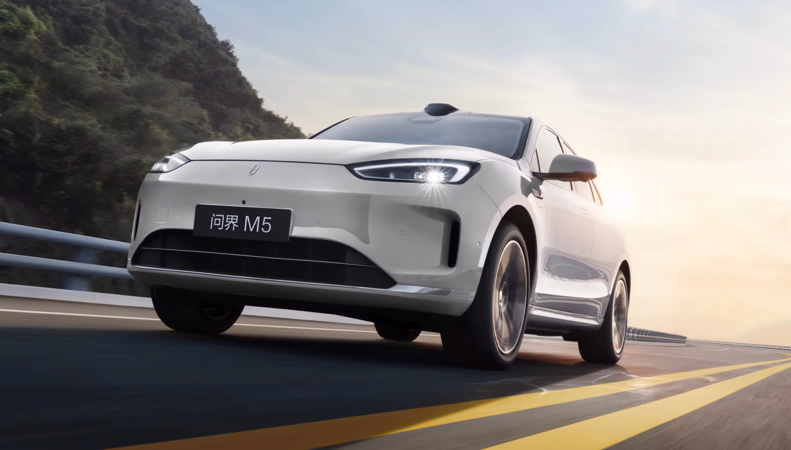 Белый AITO M5 в движении, передний ракурс