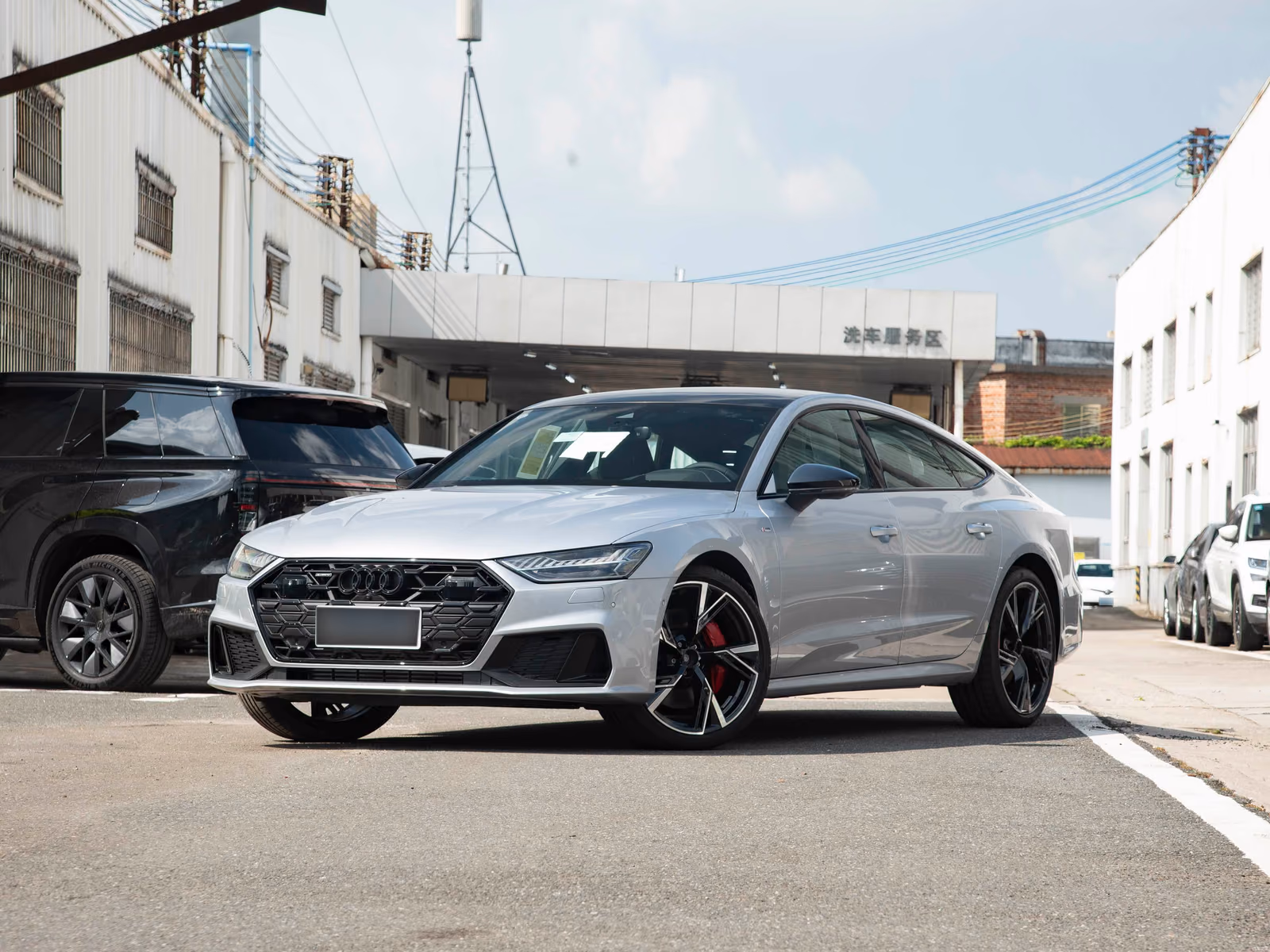 Audi A7 Sportback 55 TFSI quattro — серебристый лифтбек спереди в три четверти