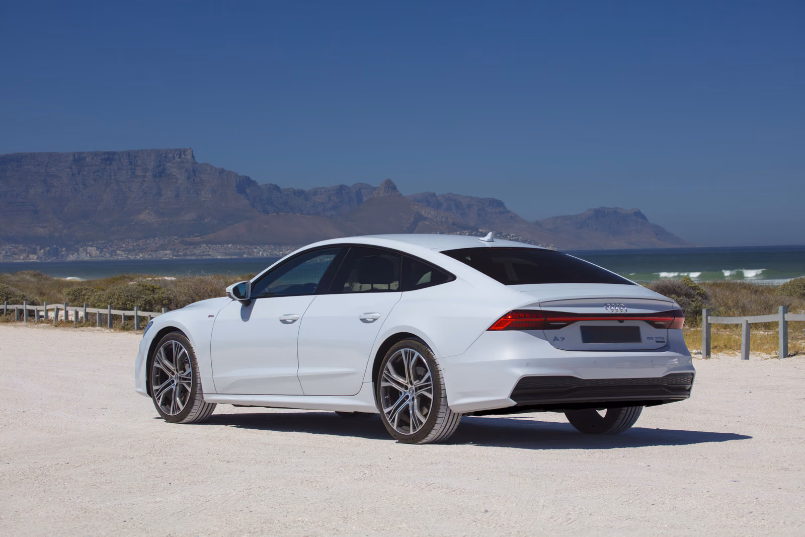 Audi A7 Sportback — белый кузов сзади в три четверти на фоне гор