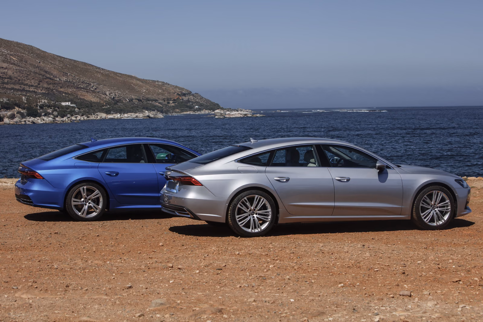 Audi A7 Sportback — синий и серебристый лифтбеки на грунтовой площадке