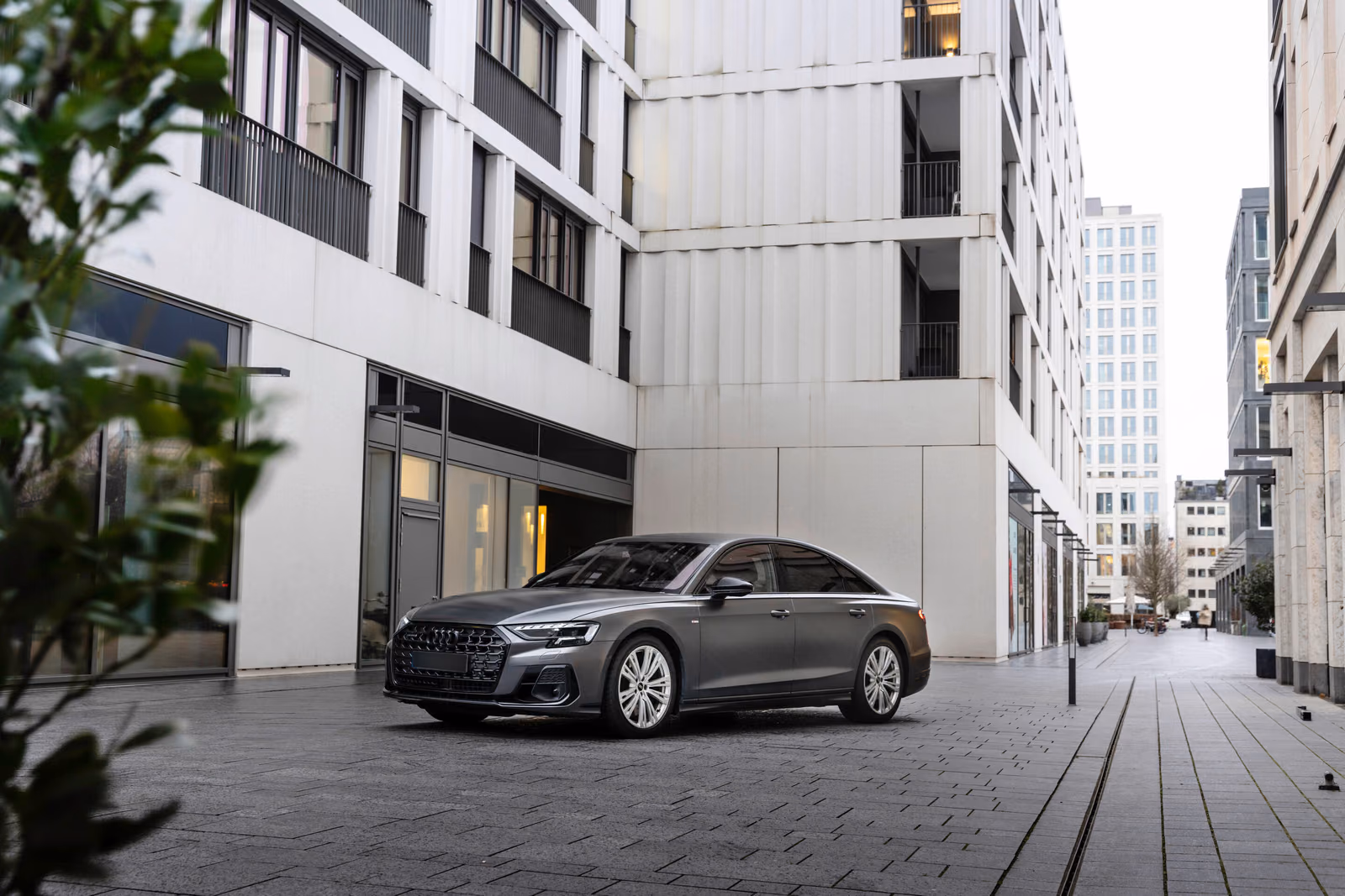 Audi A8 — серый седан во дворе современного квартала