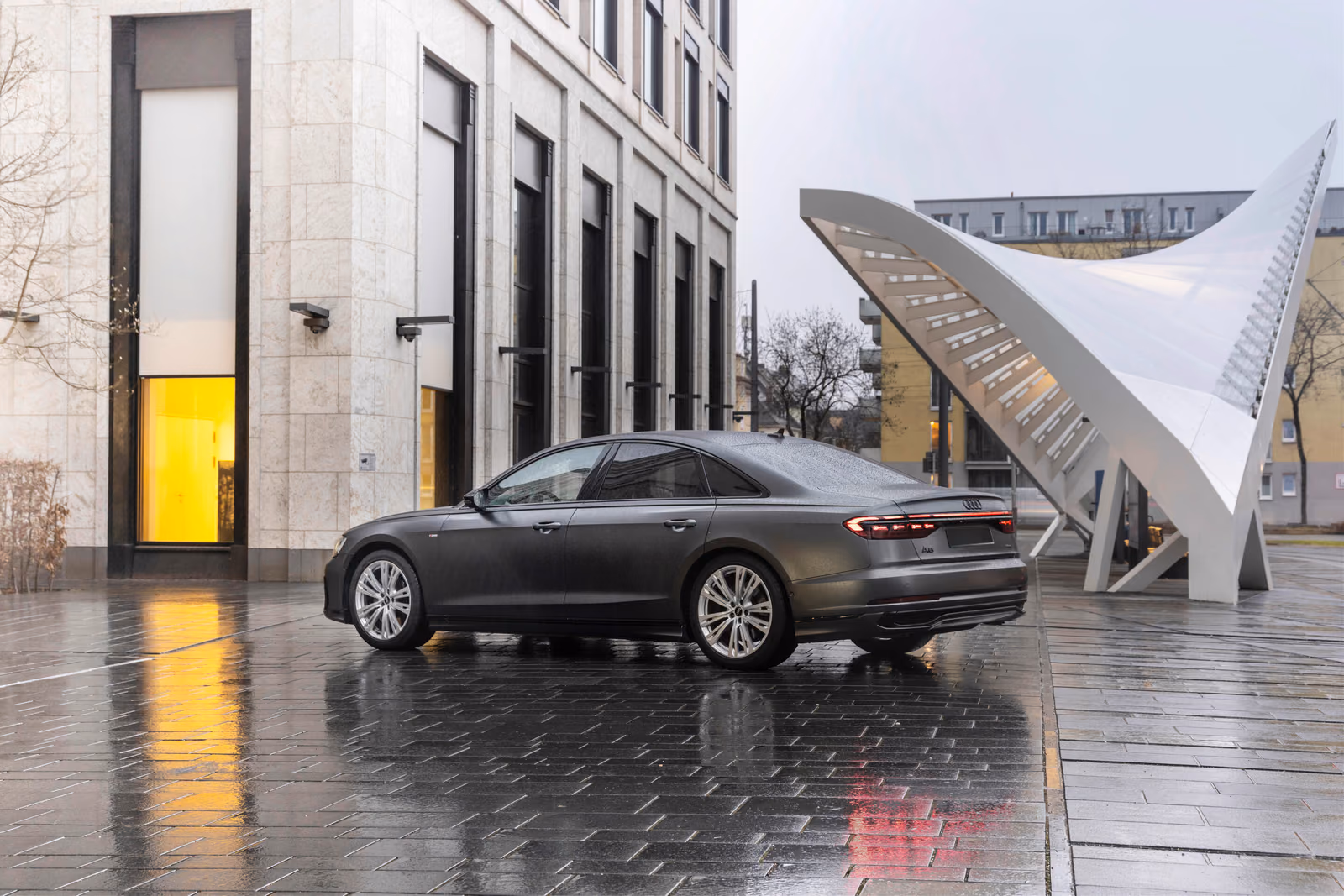 Audi A8 — профиль седана у здания с навесом