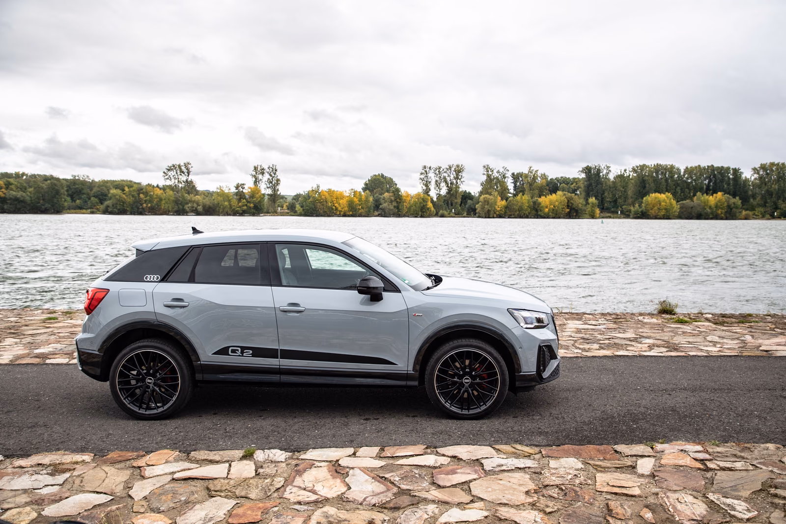 Audi Q2 — профиль серого кузова у озера