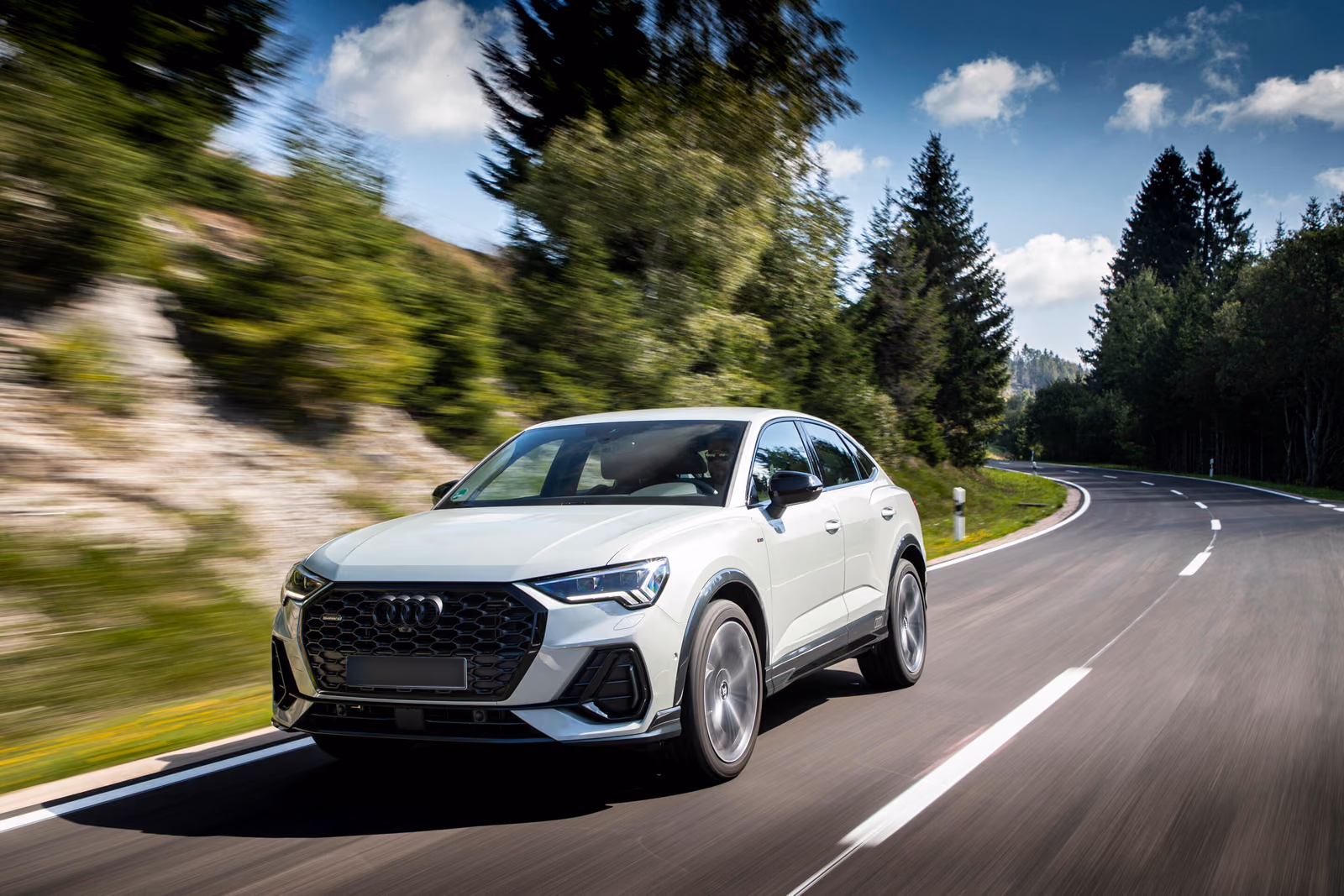 Audi Q3 — белый кроссовер в движении по лесной дороге