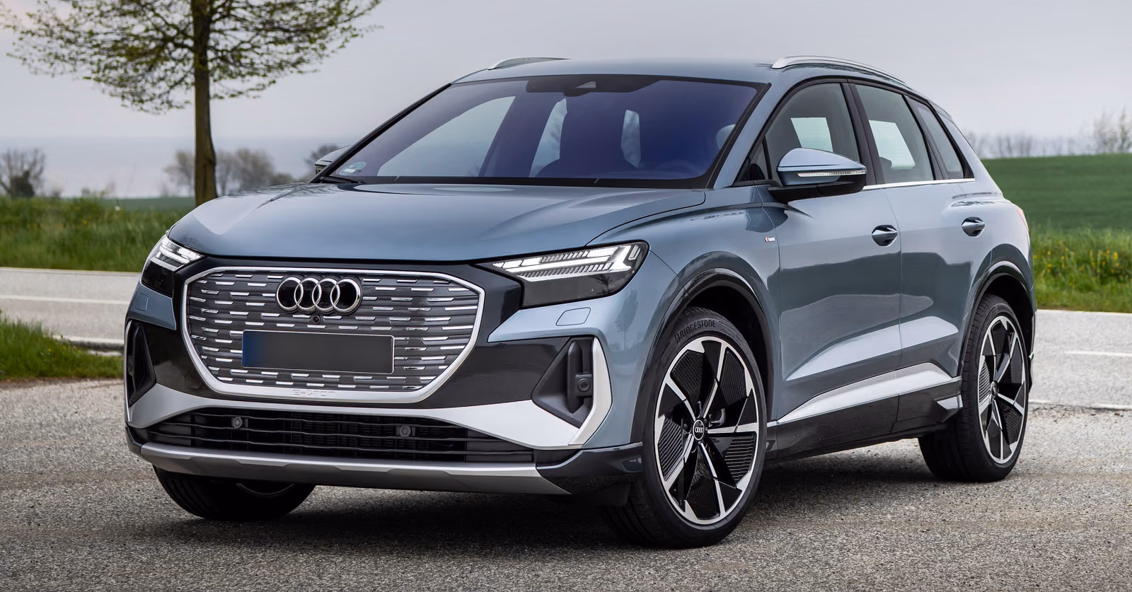 Синий Audi Q4 e-tron 2024, вид спереди в три четверти