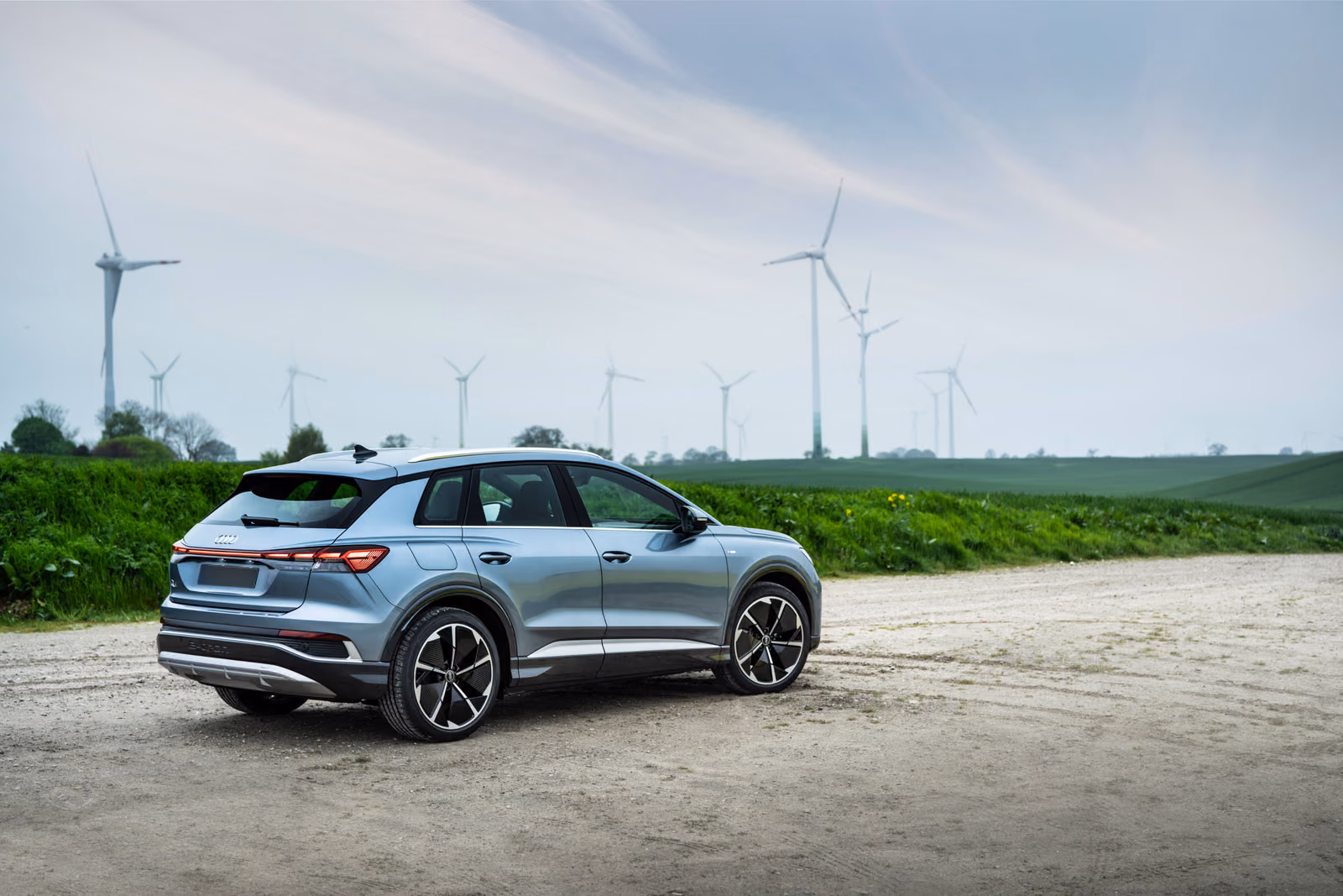 Audi Q4 e-tron у ветряков, вид спереди в три четверти