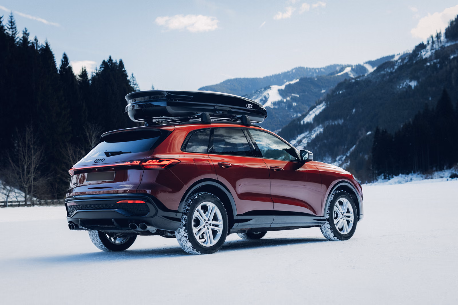 Audi Q5 — красный кроссовер с боксом на крыше, вид сзади
