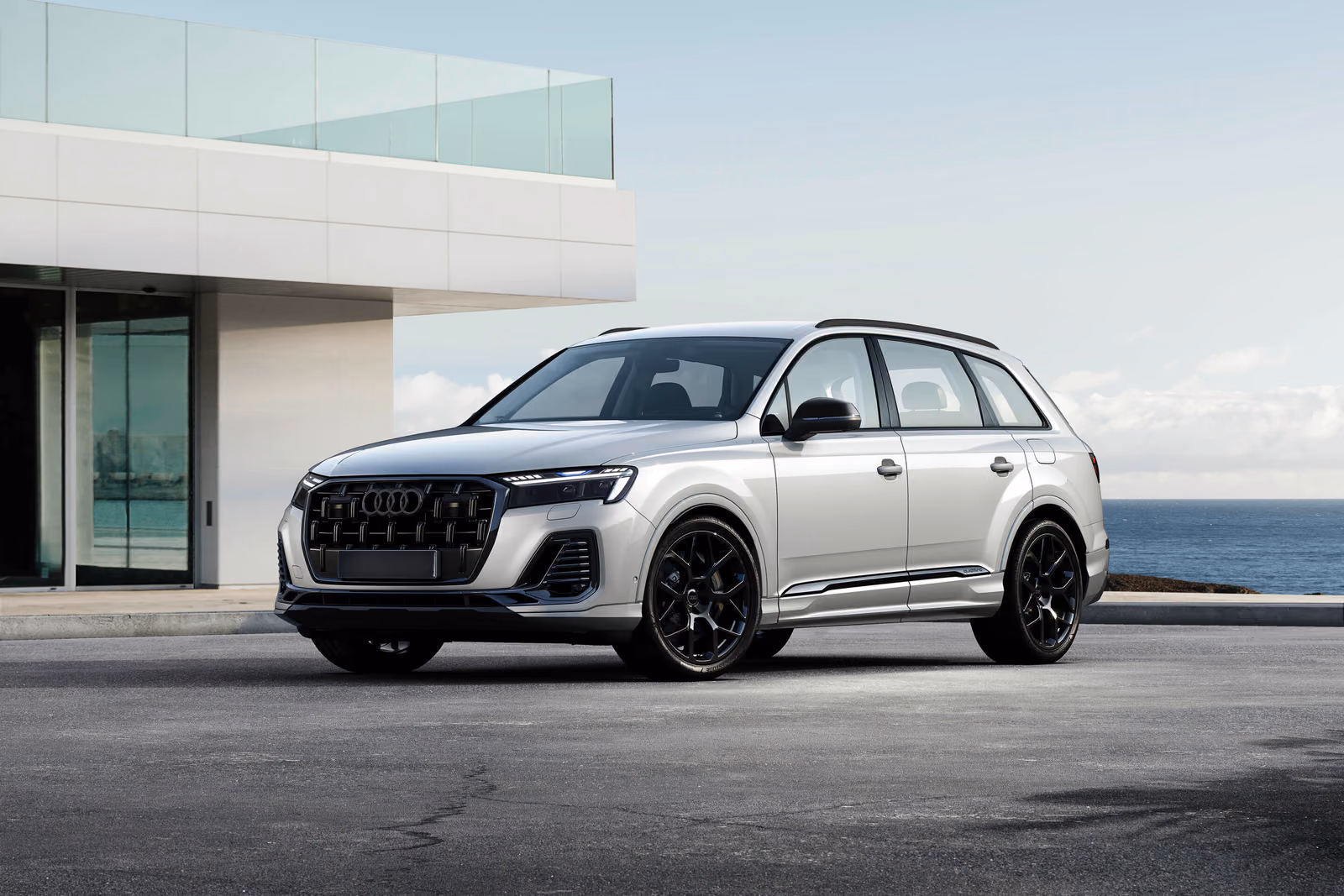 Audi Q7 — белый кроссовер у современного дома