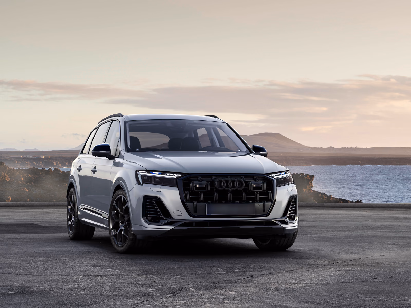 Audi Q7 — белый кузов спереди в три четверти на закате