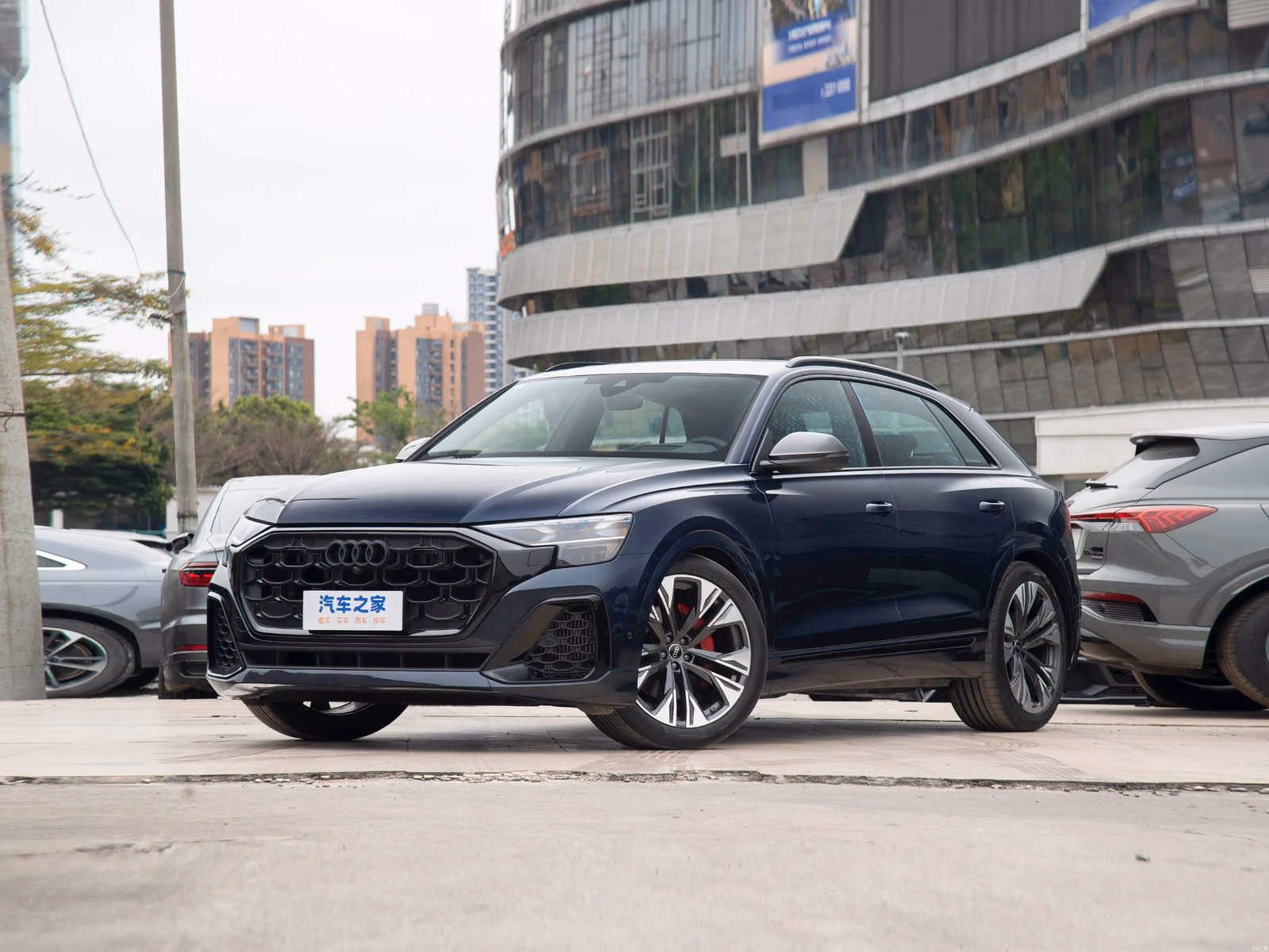 Audi Q8 55 TFSI quattro — синий кроссовер спереди в три четверти