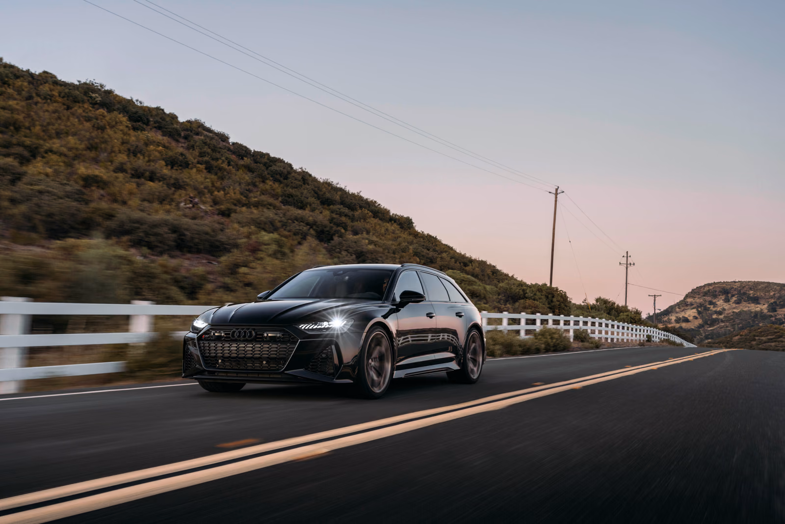 Audi RS 6 Avant performance — спереди в три четверти на дороге среди холмов