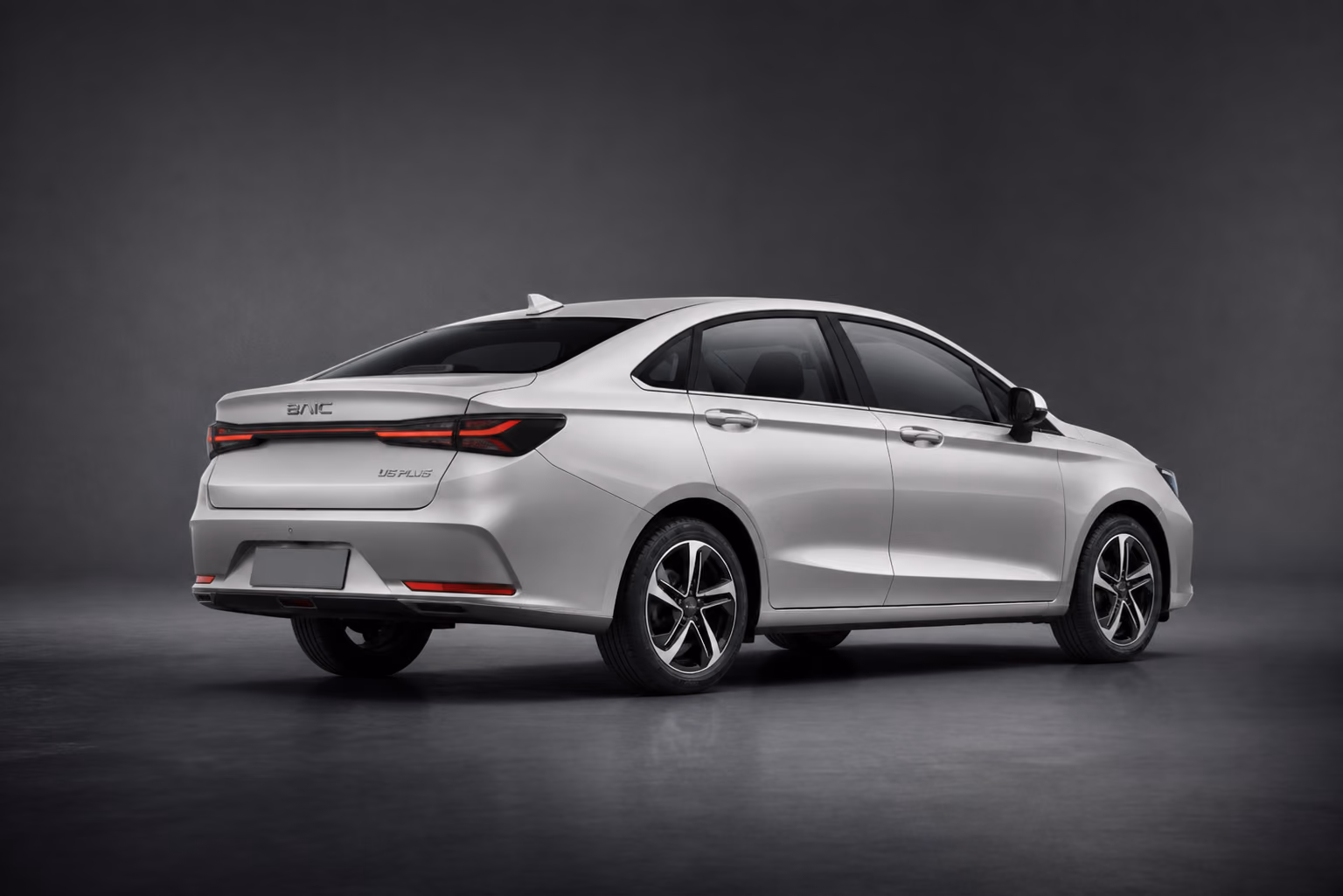 Серебристый BAIC U5 Plus сзади в тёмной студии