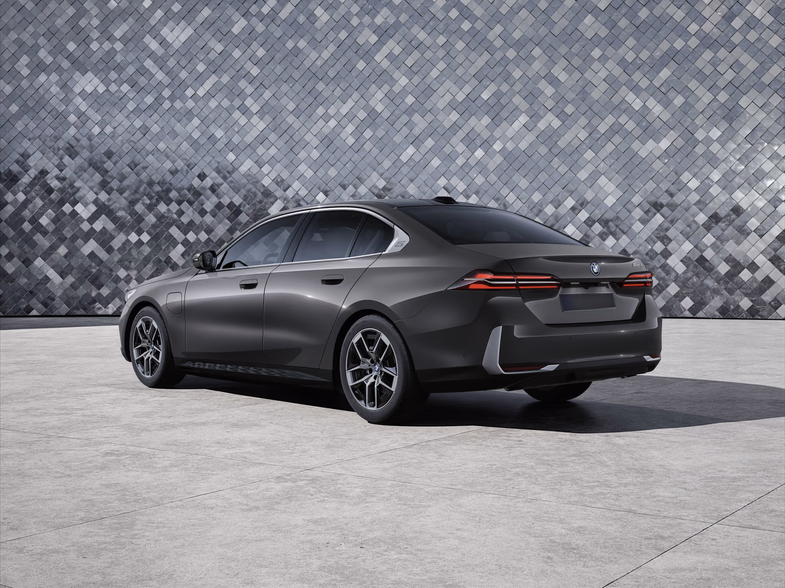 BMW 530e — вид сзади в три четверти у фасада