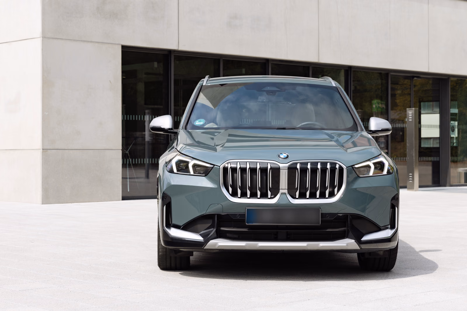 BMW X1 — у современного здания, вид спереди
