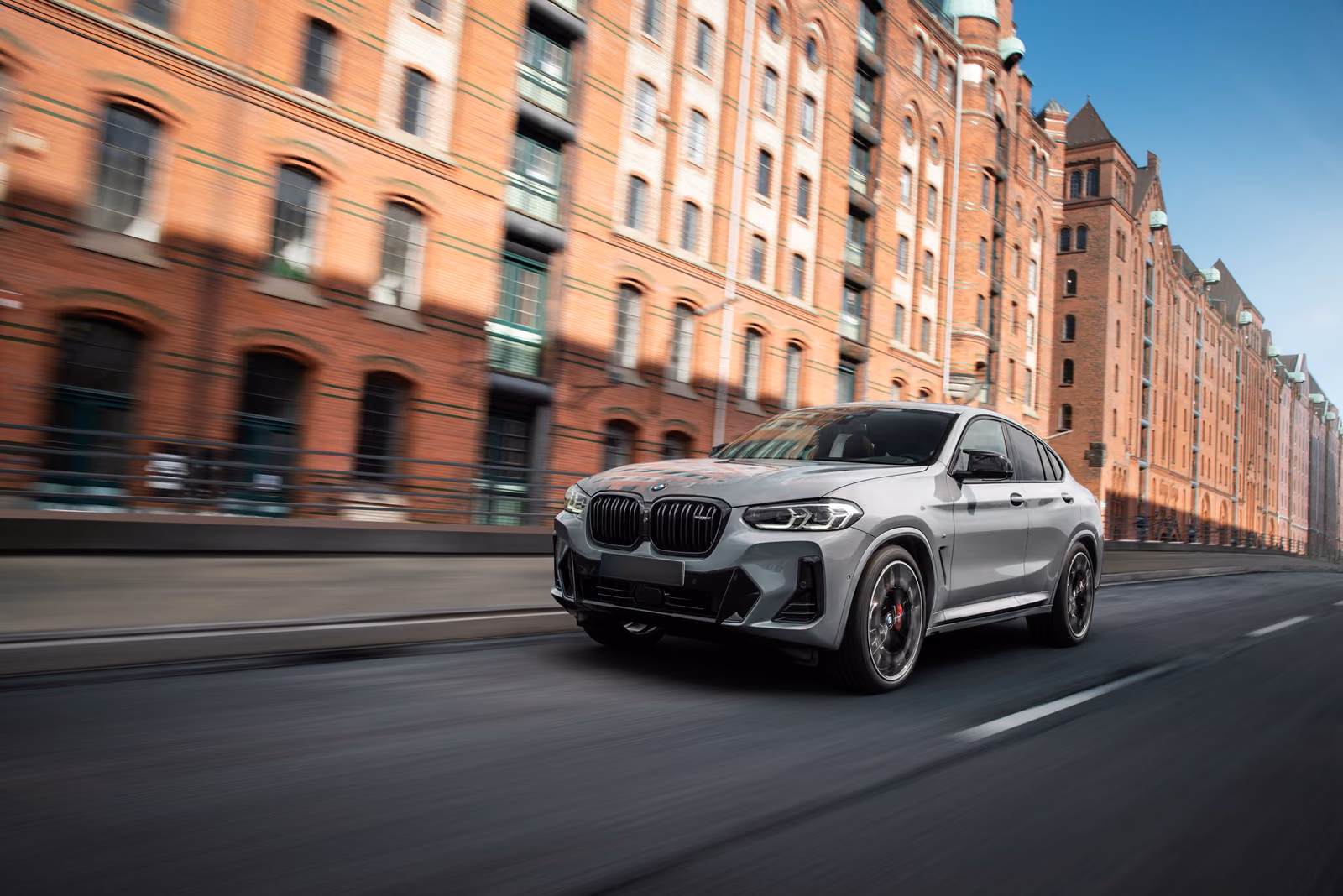BMW X4 — спереди в три четверти у кирпичных складов