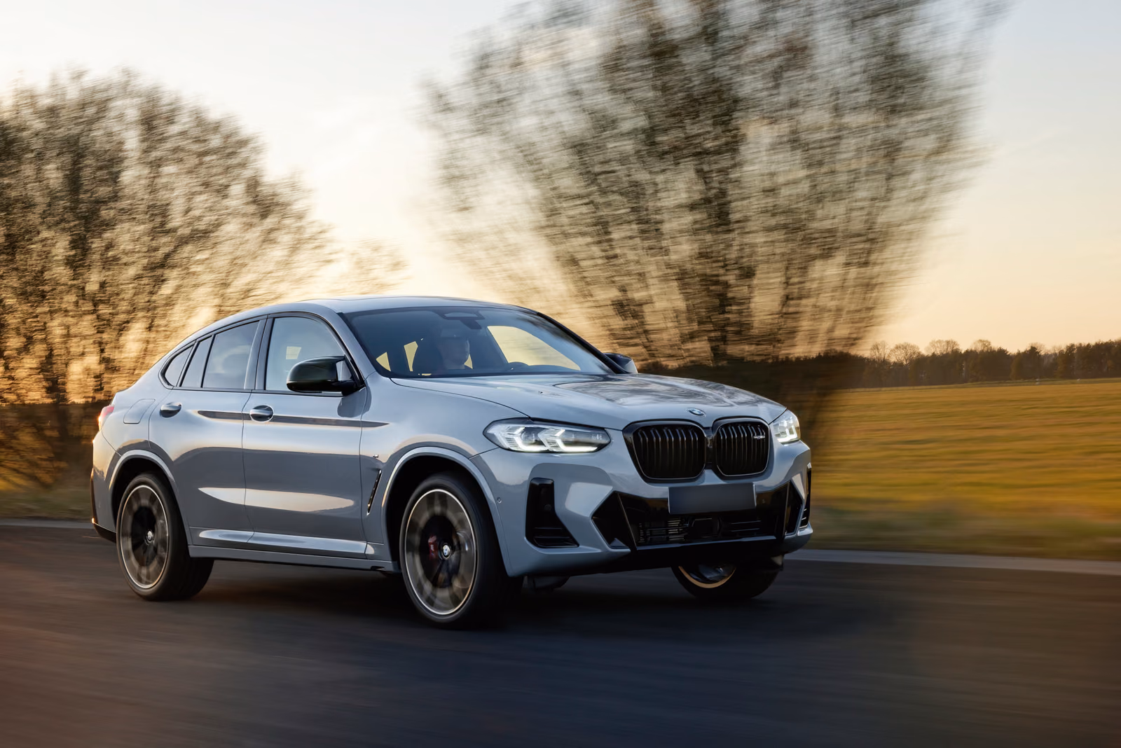 BMW X4 — на загородной дороге на закате