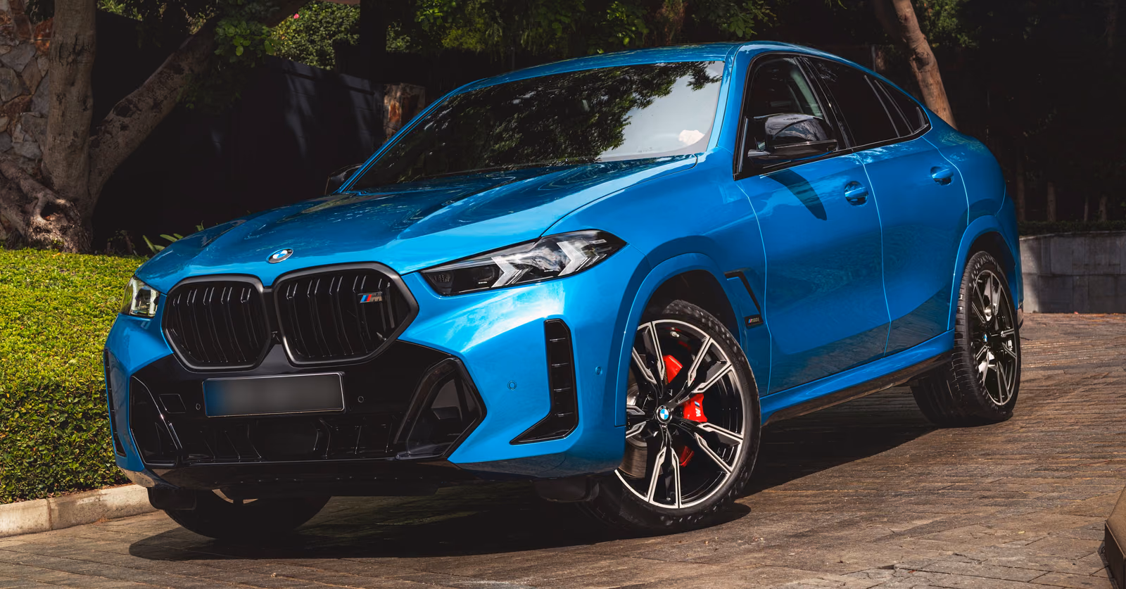 BMW X6 — рестайлинг G06, синий кузов спереди в три четверти у дома