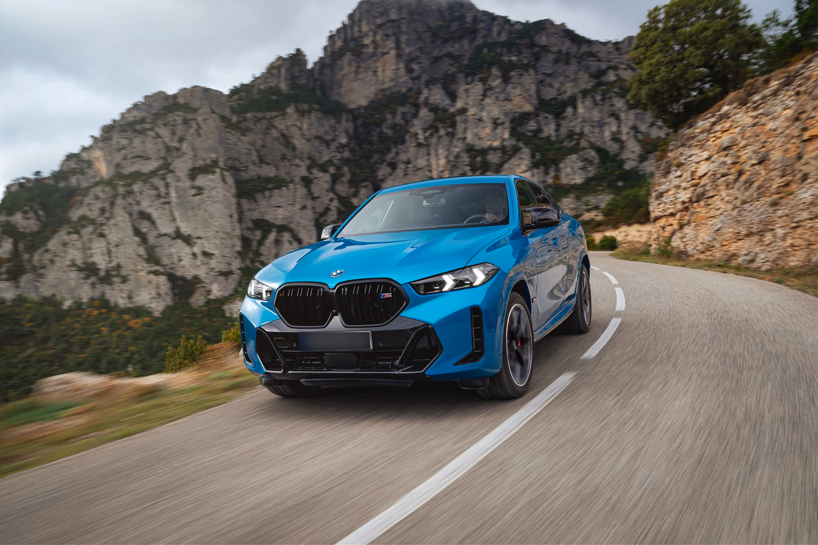 BMW X6 — спереди в три четверти на фоне скал