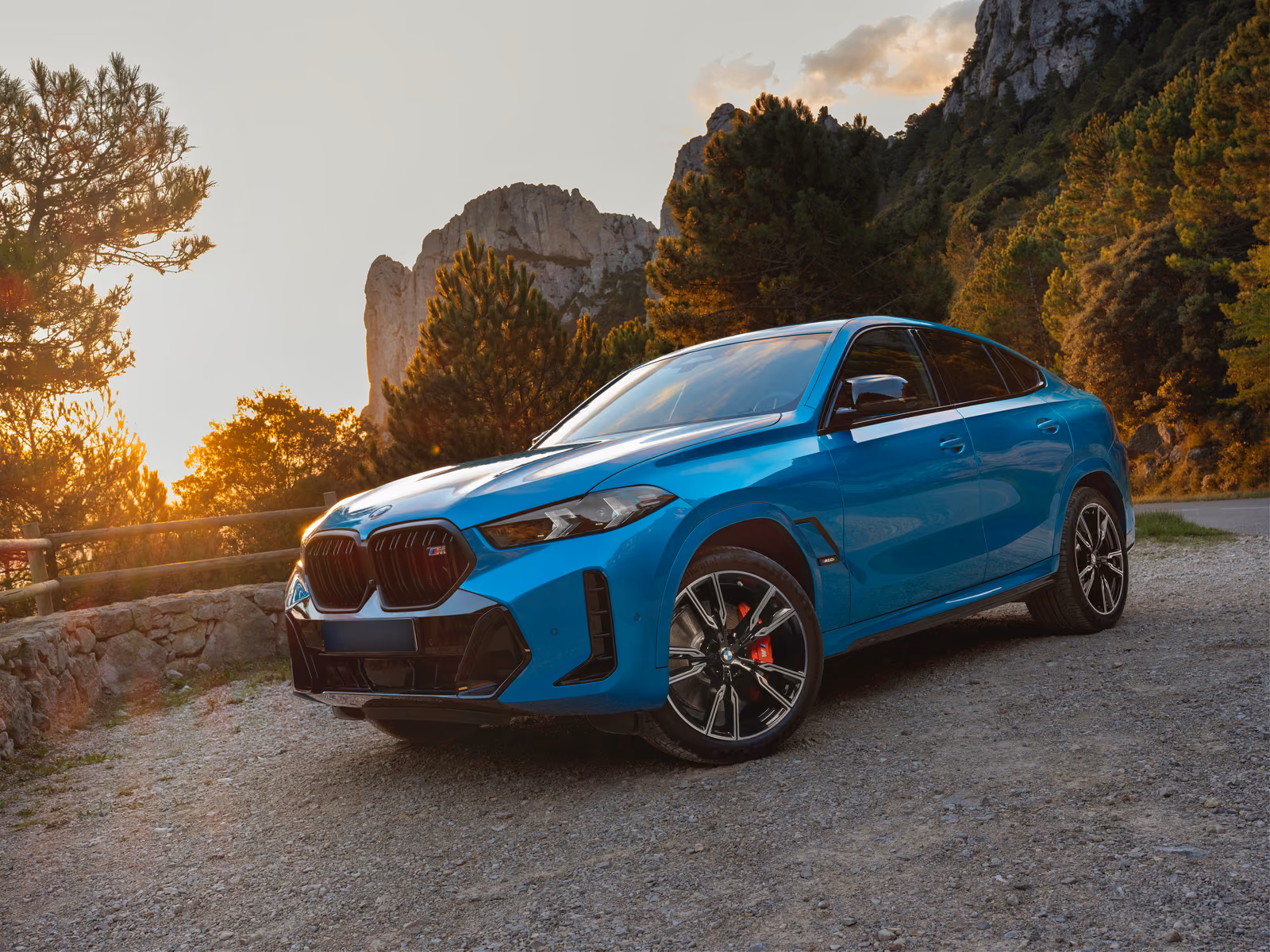 BMW X6 — спереди в три четверти на закате у скал