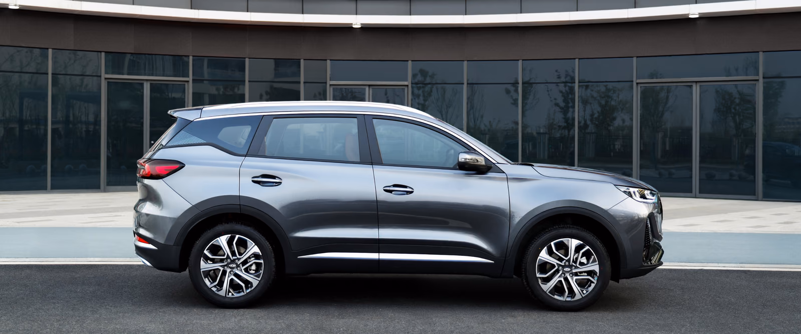 Chery Tiggo 7 в профиль у современного здания
