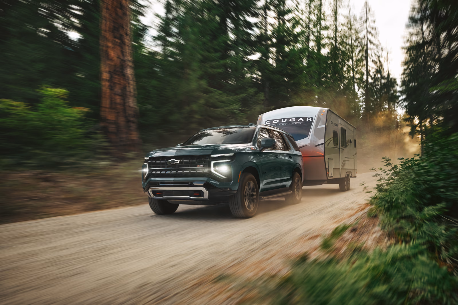 Chevrolet Tahoe 2025 — внедорожник буксирует прицеп по лесной дороге