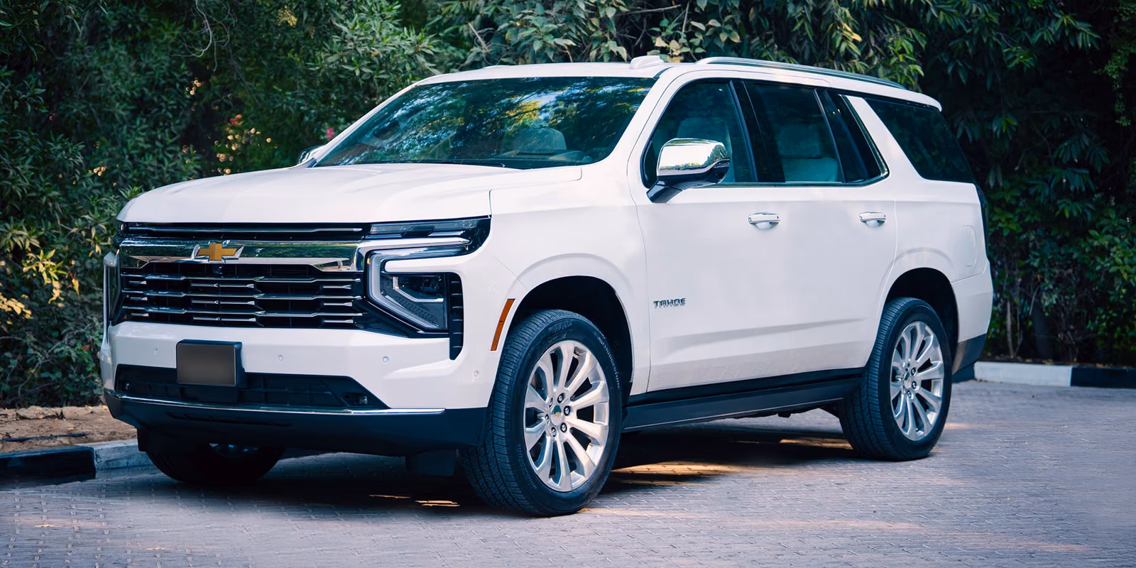 Chevrolet Tahoe — белый внедорожник спереди в три четверти