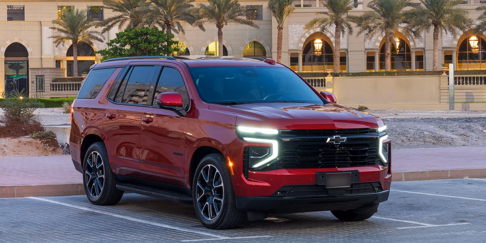 Chevrolet Tahoe — красный внедорожник с включёнными ходовыми огнями