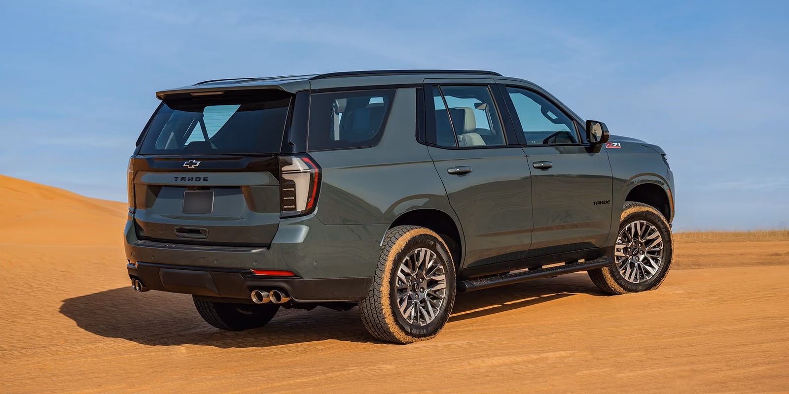 Chevrolet Tahoe — задняя часть в три четверти на песке