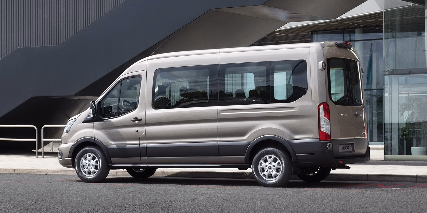 Серебристый Ford Transit в пассажирской версии, вид сбоку