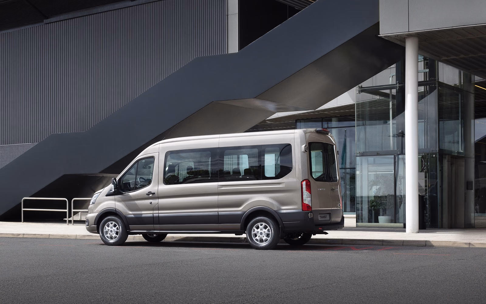 Пассажирский Ford Transit у здания, вид спереди в три четверти