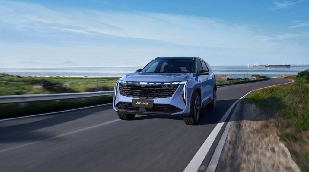 Geely Atlas в движении по загородной дороге