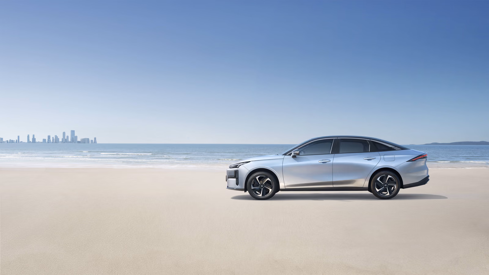 Серебристый Geely Galaxy L6 на пляже, профиль