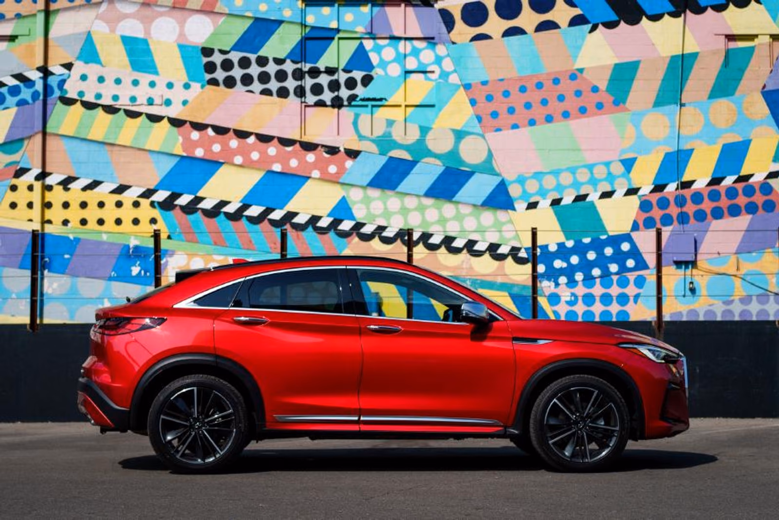 Infiniti QX55 в профиль на фоне городского мурала