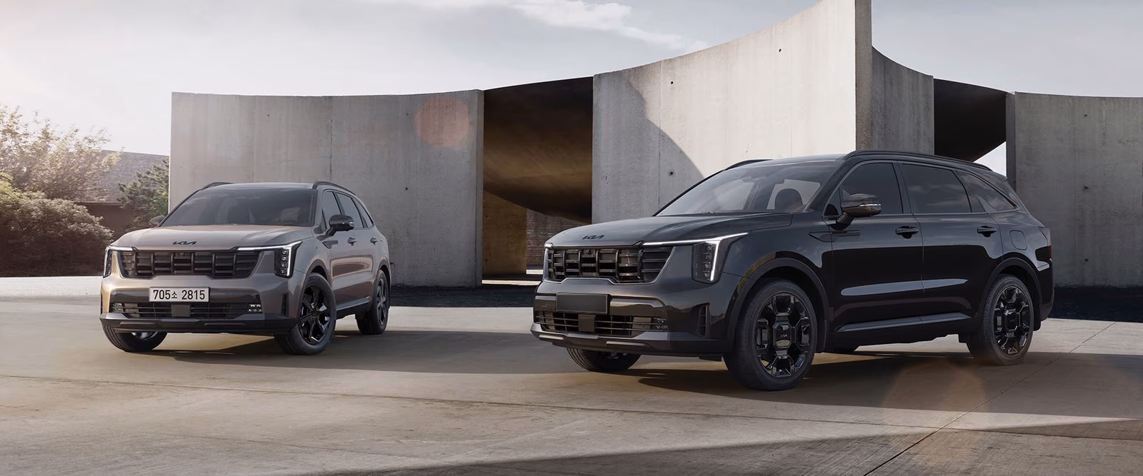 Kia Sorento X-Line — вид спереди в три четверти на фоне бетонной архитектуры