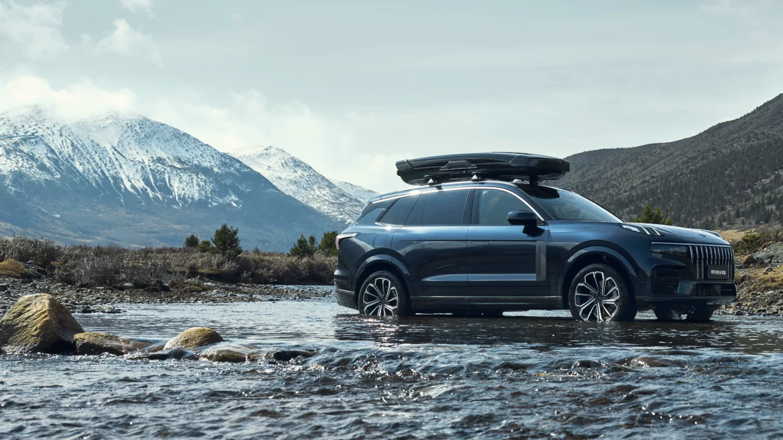 Lynk & Co 09 с боксом на крыше у горной реки