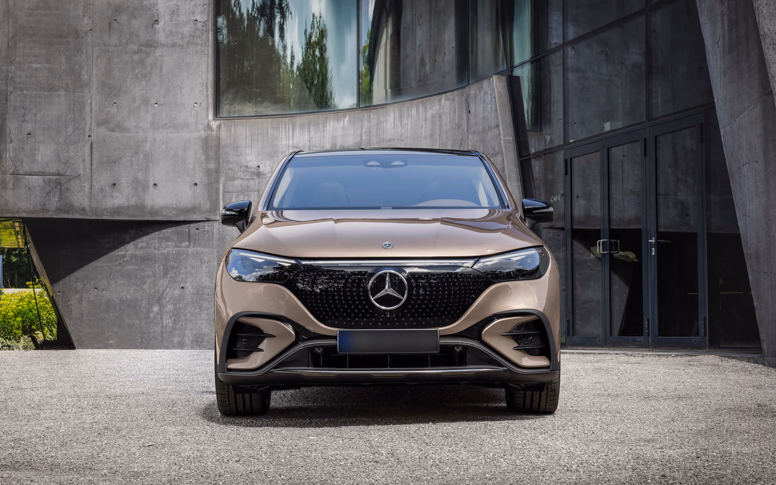 Mercedes-Benz EQE SUV — вид строго спереди у бетонного фасада
