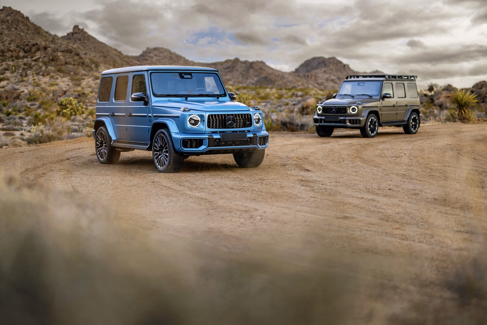 Mercedes-Benz G-Class — голубой и оливковый внедорожники на грунтовой дороге
