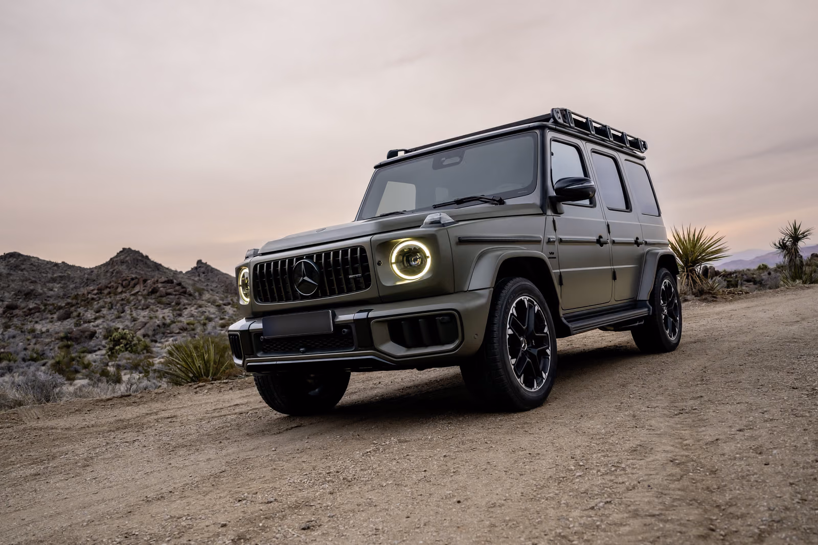 Mercedes-Benz G-Class — спереди в три четверти среди камней и юкк