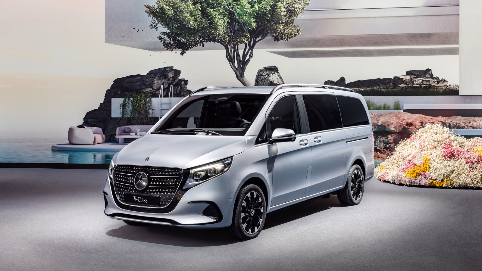 Mercedes-Benz V-Class — серебристый минивэн на фоне моря и деревьев