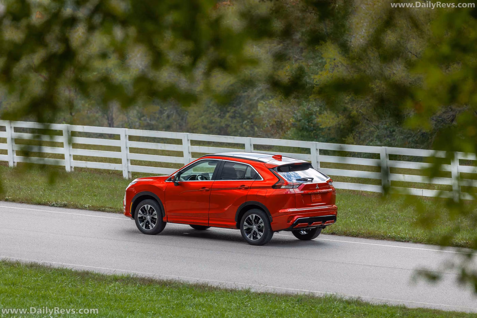 Mitsubishi Eclipse Cross на дороге вдоль забора