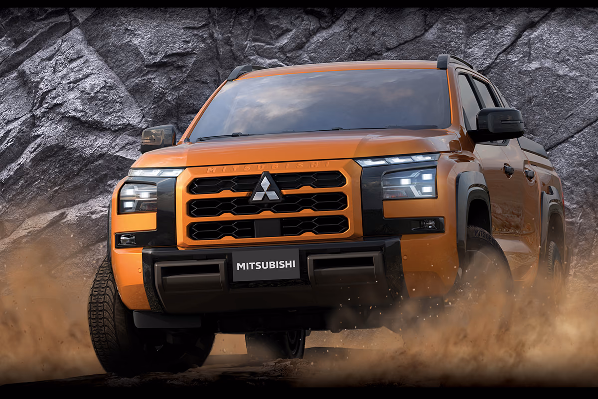 Mitsubishi L200 — оранжевый пикап в движении по грунту