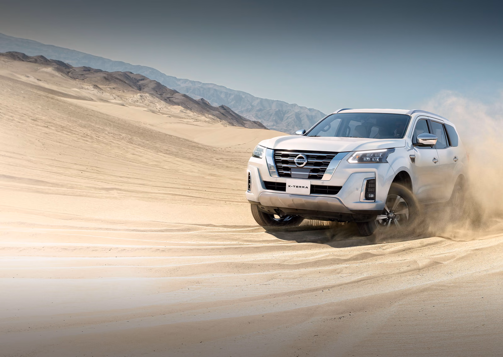 Белая Nissan X-Terra в движении по песку