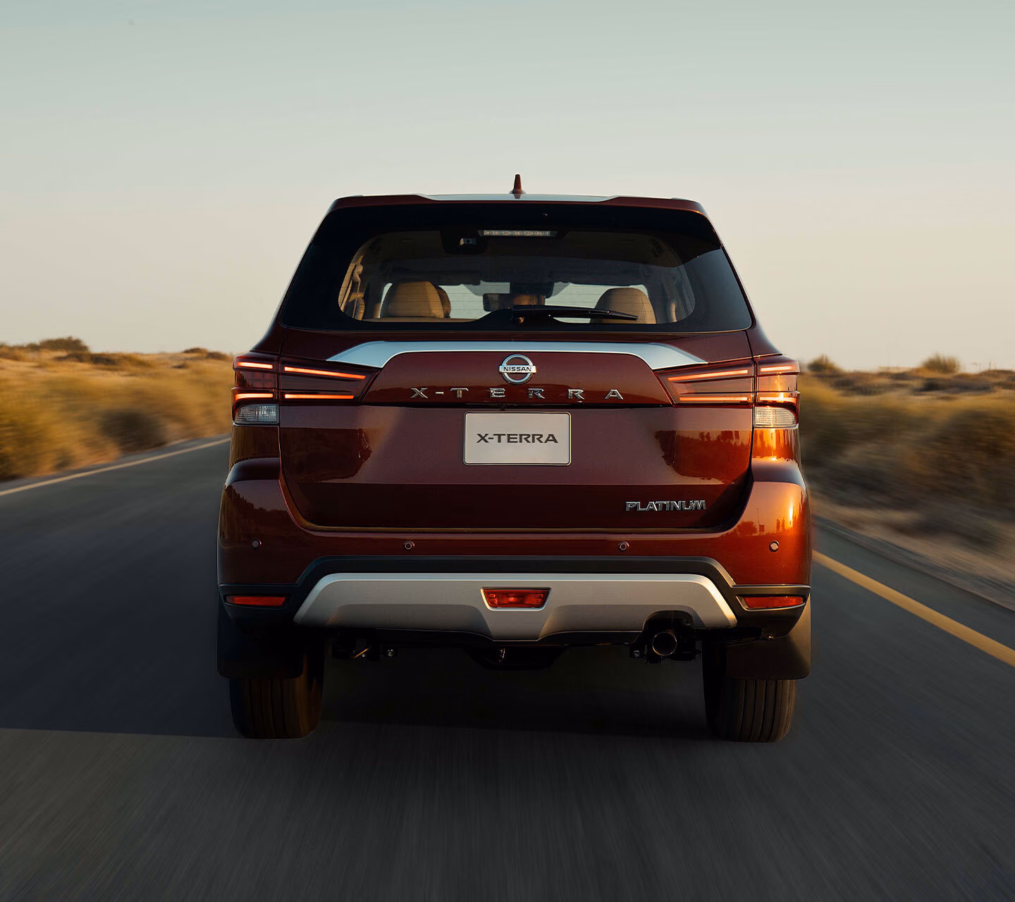 Nissan X-Terra сзади на пустынной дороге