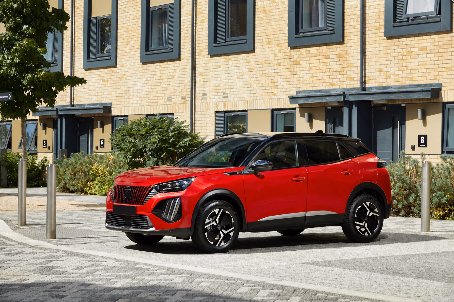 Peugeot 2008 — красный кузов GT спереди и сбоку на городской улице