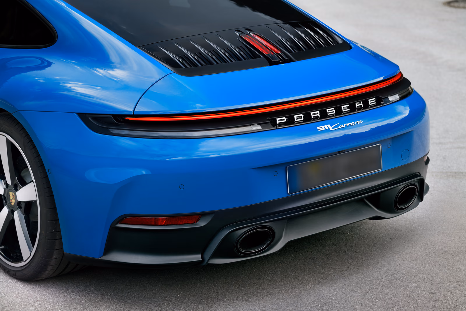 Porsche 911 Carrera — вид сзади в три четверти со сплошной световой полосой