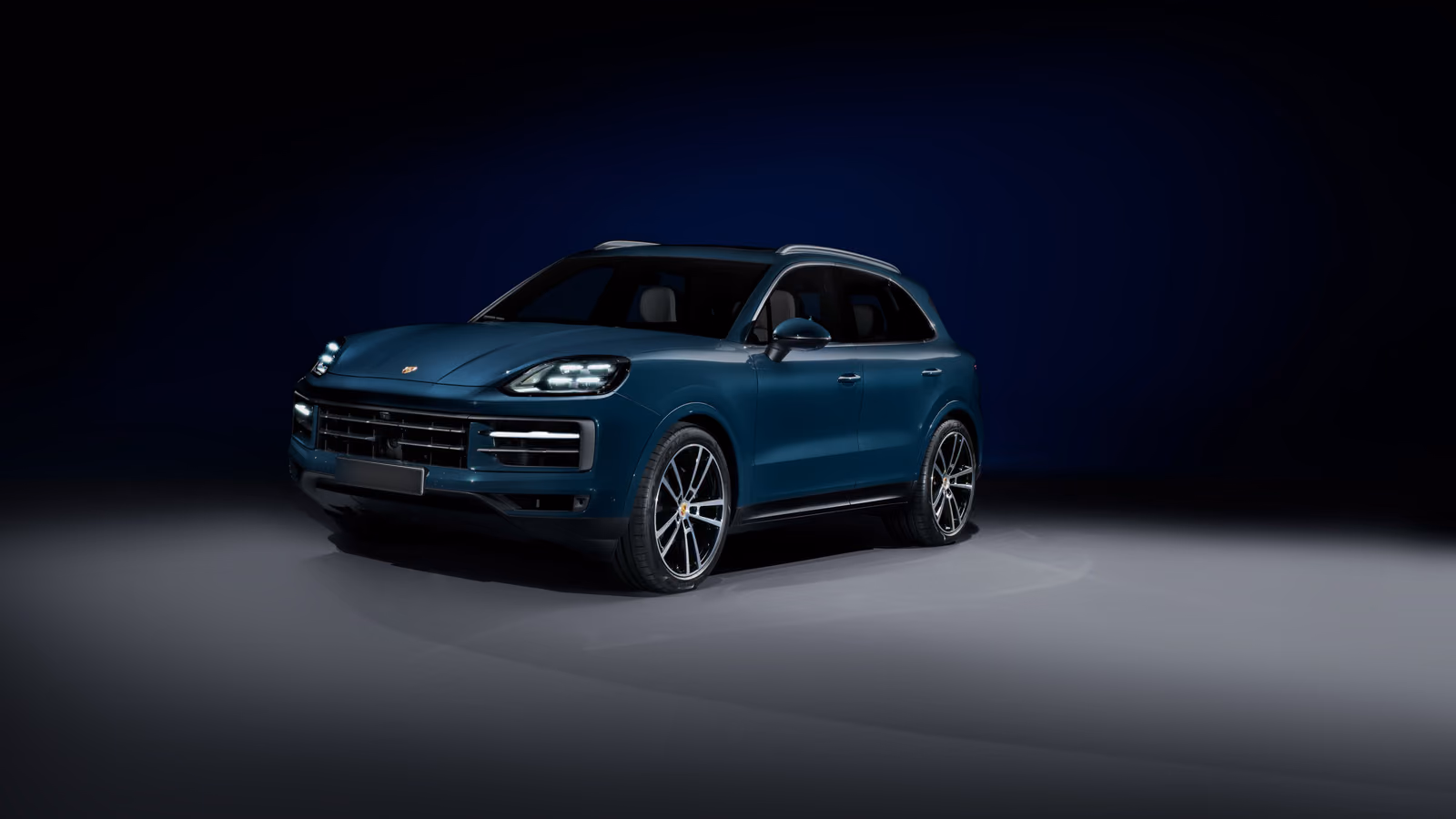 Синий Porsche Cayenne 2024 в студии, вид спереди в три четверти