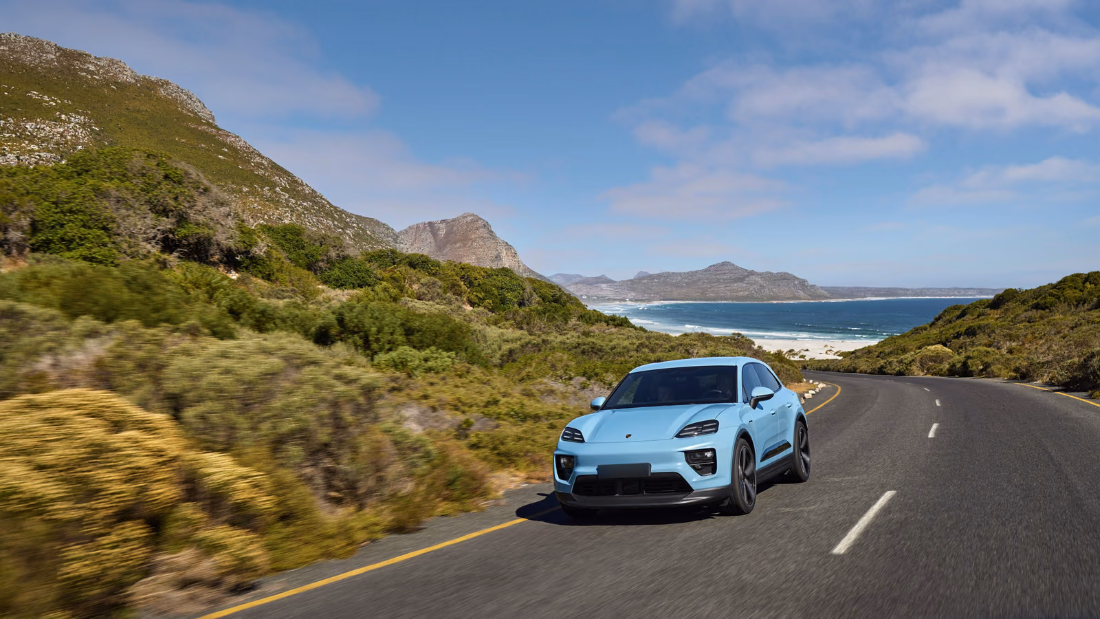 Porsche Macan Electric в движении, вид сзади в три четверти