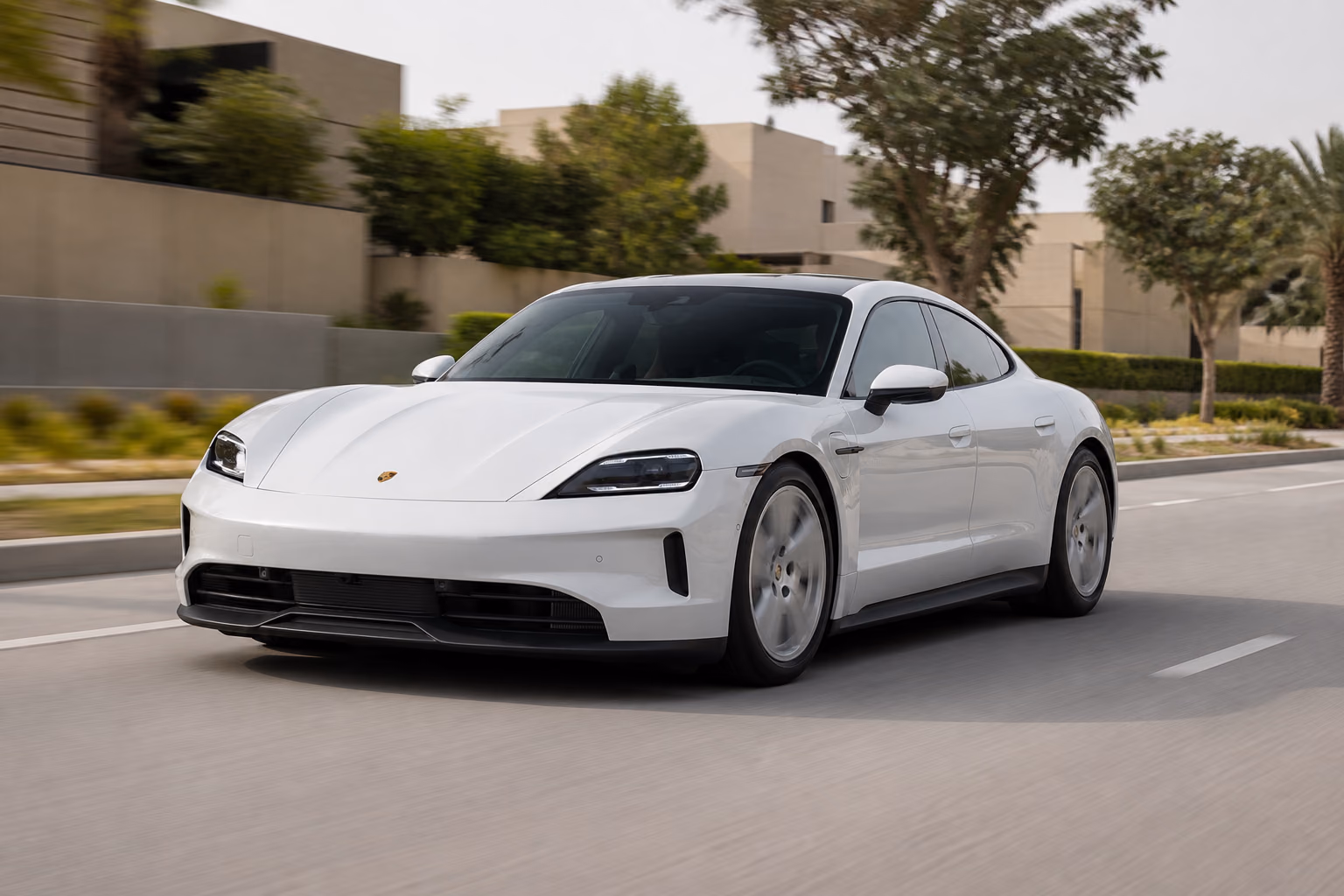 Porsche Taycan на городском проспекте у пригородной застройки