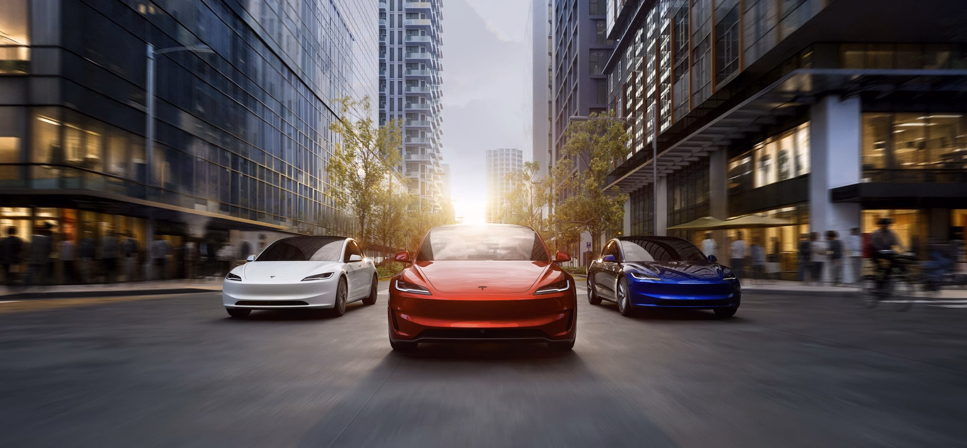 Три Tesla Model 3 разных цветов на городской улице