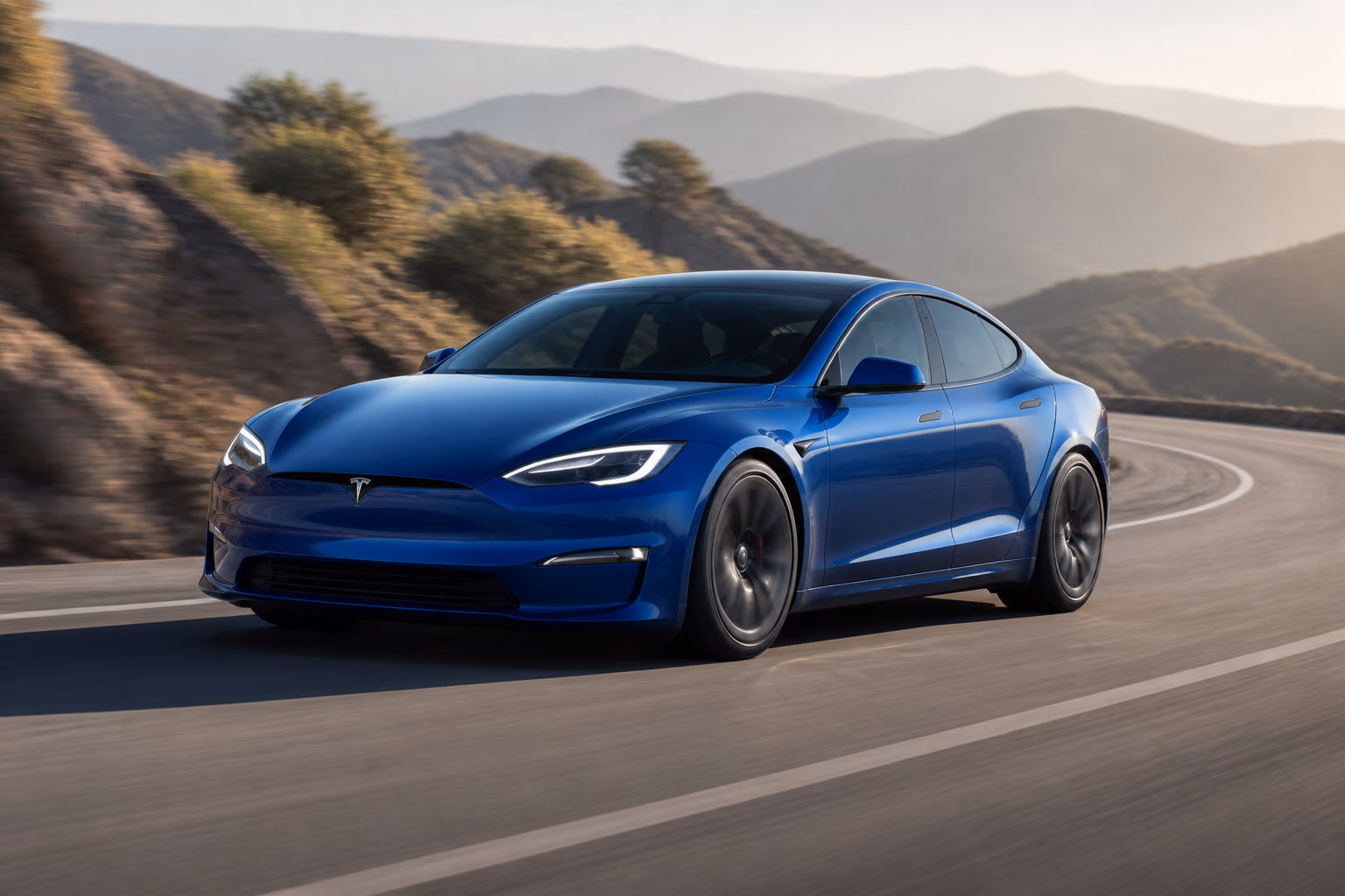 Синий Tesla Model S на пустой извилистой горной дороге